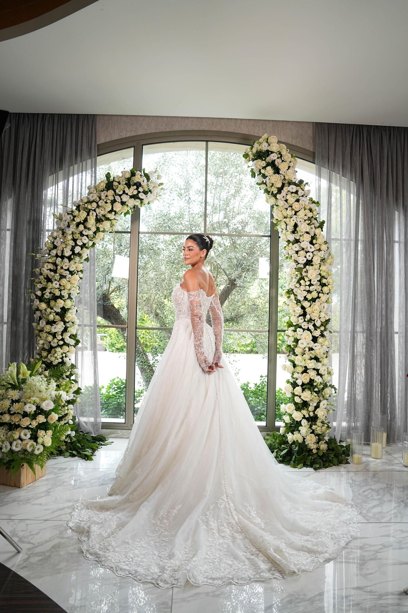 Bride under a white flower arch at Monte Cassino