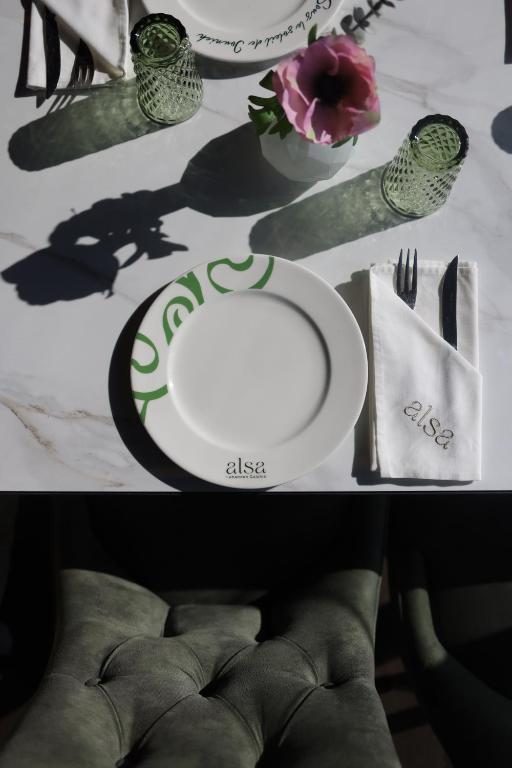 ALSA plate, napkin and green glassware on a marble table